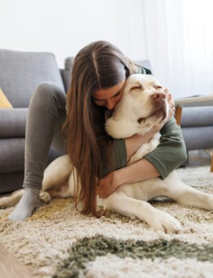 Woman cuddling and hugging her pet dog